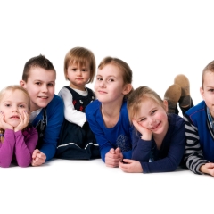 Niestadt-fotografie-Schoonhoven-studio-shoot-met-neven-en-nichten-liggen-samen-op-een-witte-achtergrond