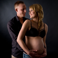 Niestadt-Fotografie-Schoonhoven-zwangerschaps-shoot-sfeervol-licht-tegen-zwarte-achtergrond-met-vriend